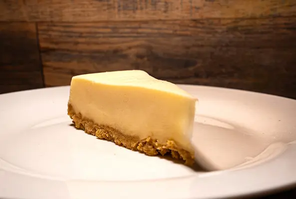 Slice of cheesecake on a white plate.